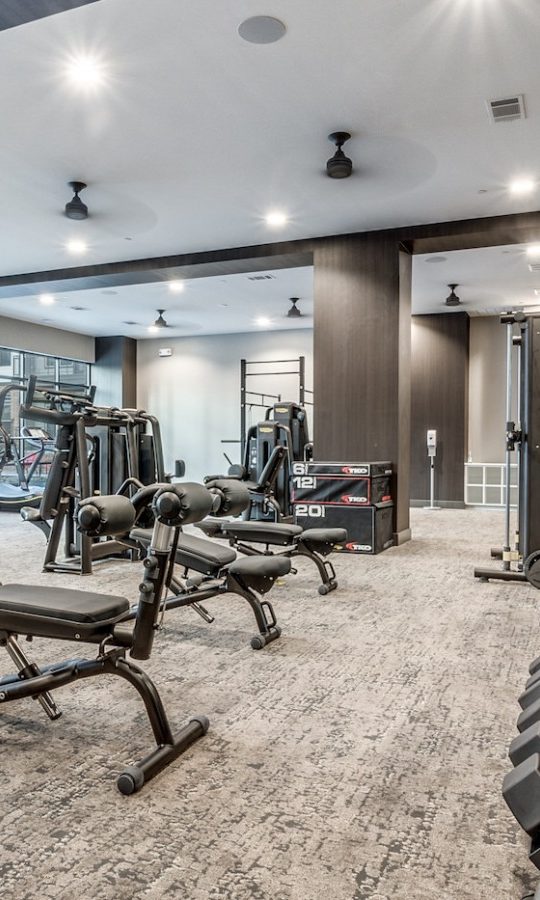 a gym room with exercise equipment and mirrors at The Cedar at  Branch