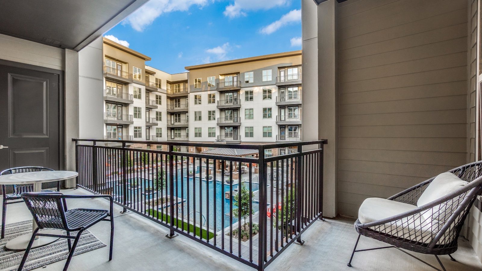 balcony with patio furniture and pool at The Cedar at Branch