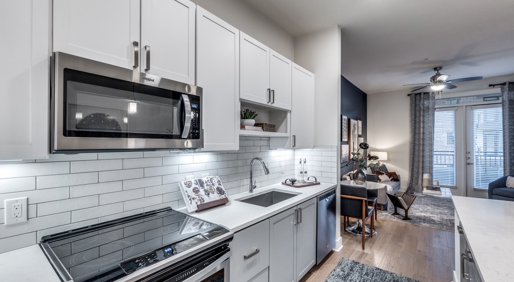 a kitchen with white cabinets and stainless steel appliances at The Cedar at  Branch
